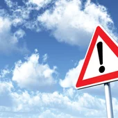 Warning sign against cloud backdrop