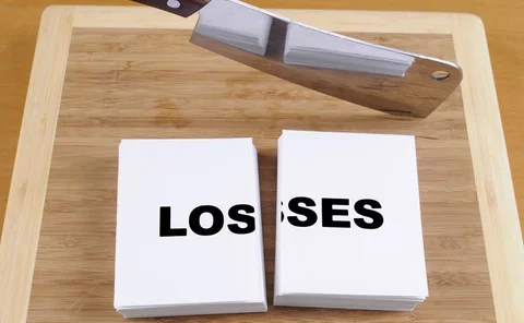 A meat cleaver cutting through the word losses