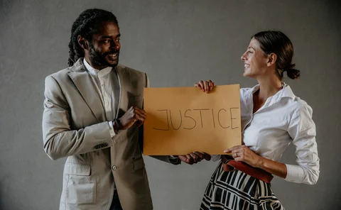 Multicultural businessman's holding JUSTICE board and trying to change people's mindset. Let's keep it up with this