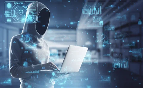 Hacker in hoodie using laptop with abstract creative business charts and binary code on blurry office interior background. System engineering and digital transformation concept. Double exposure