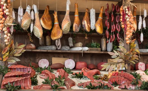 Variety of Raw Meat and sausages in Butcher Shop on Wooden Board